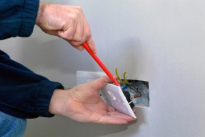 The hands of an electrician installing a power socket